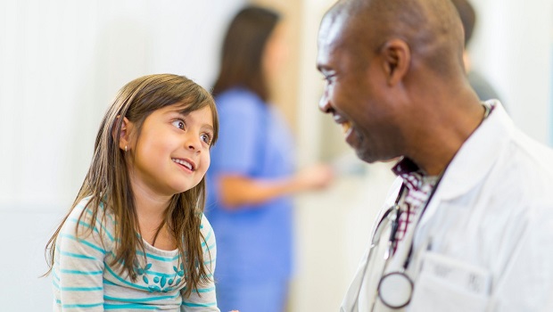 Physician speaking with young girl patient.