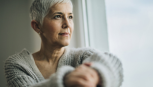 Woman looks out window reflectively