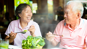 Senior couple at table eating a healthy meal