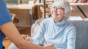 Senior woman getting up out of chair