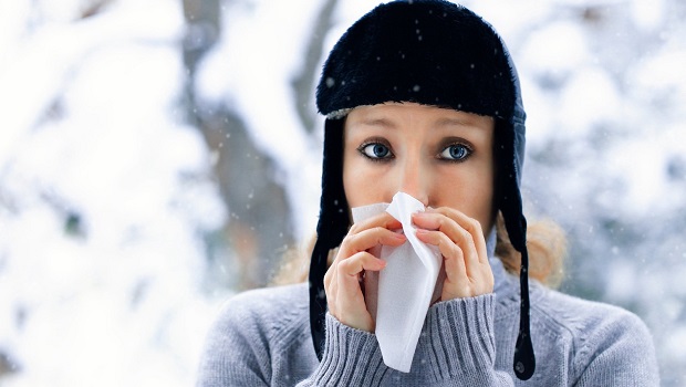 Young woman blowing her nose.