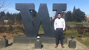 Kayne Mettert standing in front of University of Washington school sculpture